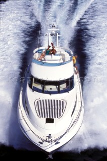 Male and female models relaxing and socialising on a luxury Fairline powerboat