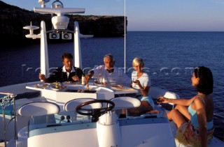 Male and female models relaxing and socialising on a luxury Fairline powerboat