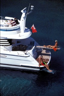 Male and female models relaxing and socialising on a luxury Fairline powerboat