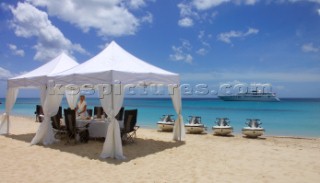 Dining and lunch on a beach by a moored superyacht