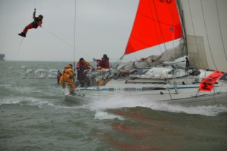 Coastguard being winched down from Helicopter to Yacht Innovation in Rescue Mission