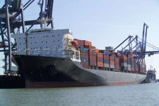 A commercial container ship being unloaded at the quayside