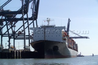 A commercial container ship being unloaded at the quayside