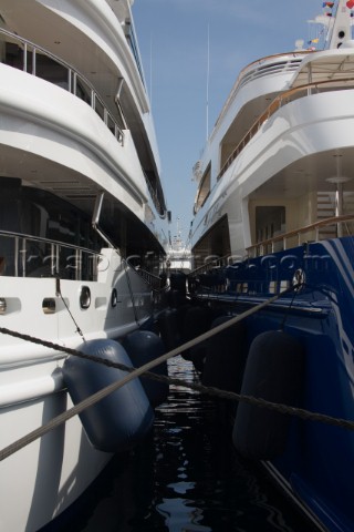Two superyachts with fenders and bouys moored in the harbour port of Monaco