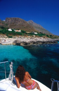 Sicily Italy. A lady relaxes on the deck of a boat