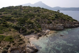 Aerial view of a lone dinghy nestling on a sandy beach of an island