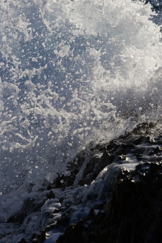 Close up of a wave breaking over the rocks