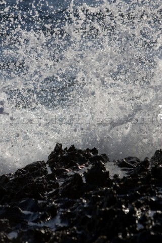 Close up of a wave breaking over the rocks