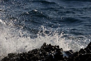 Close up of a wave breaking over the rocks