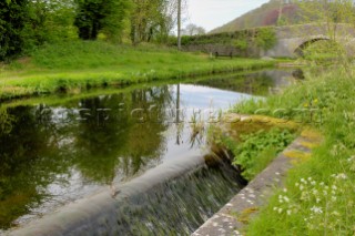 By-wash above Brithdir locks,Montgomery Canal,with bridge 125 in the background,near Berriew,Powys,Wales,UK.May 2006.