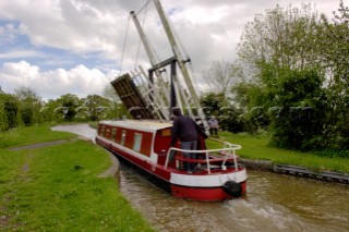 Narrow boat passing through Allmans lift bridge No.1,Prees branch,Llangollen canal,near Whixall,Shropshire,England,UK.May 2006.