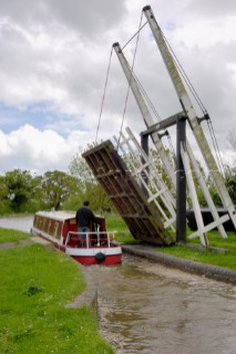 Narrow boat passing through Allmans lift bridge No.1,Prees branch,Llangollen canal,near Whixall,Shropshire,England,UK.May 2006.