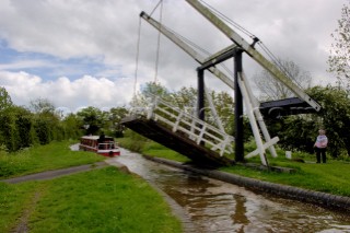 Narrow boat passing through Allmans lift bridge No.1,Prees branch,Llangollen canal,near Whixall,Shropshire,England,UK.May 2006.