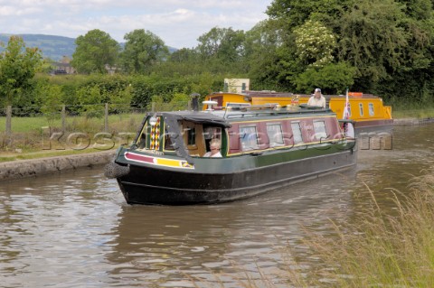 Man and woman  on narrow boat approaching the Jack Mytton Inn on the Llangollen canalnear HindfordWh