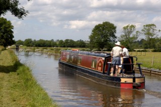 Man and woman on narrowboat approaching New Marton bottom lock,Llangollen canal,New Marton,Shropshire,England.June 2006.