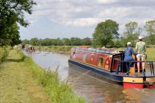 Man and woman on narrowboat approaching New Marton bottom lock,Llangollen canal,New Marton,Shropshire,England.June 2006.