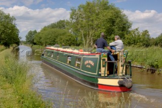 Man and woman on narrowboat approaching New Marton bottom lock,Llangollen canal,New Marton,Shropshire,England.June 2006.