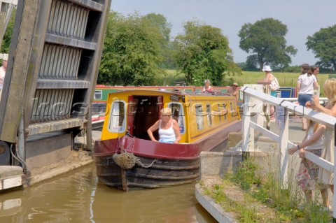 Woman on narrow boat passing through Wrenbury lift bridge on the Llangollen canalWrenburyCheshireEng