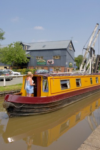 Woman on narrow boat passing through Wrenbury lift bridge on the Llangollen canalWrenburyCheshireEng