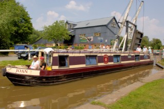 People on narrow boat passing through Wrenbury lift bridge on the Llangollen canal,Wrenbury,Cheshire,England.July 2006.