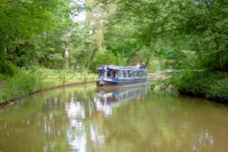 Man and woman on narrow boat approaching Ellesmere tunnel,Llangollen canal,Ellesmere,Shropshire,England.July 2006.