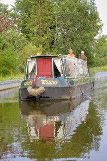 Men on narrow boat approaching Maesbury wharf on the Montgomery canal,Maesbury,Shropshire,UK.July 2006.