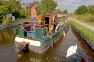 Men on narrow boat mooring up at Maesbury wharf on the Montgomery canal,Maesbury,Shropshire,UK.July 2006.