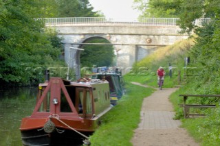 Narrow boats and cyclist by bridge 14 on the Shropshire Union canal at Brewood,Staffordshire,England.September 2006.