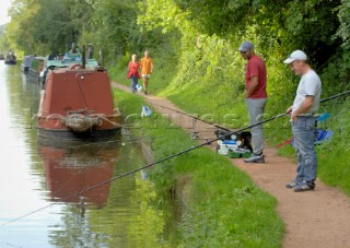 Narrow boats,fishermen and walkers by bridge 14 on the Shropshire Union canal at Brewood,Staffordshire,England.September 2006.