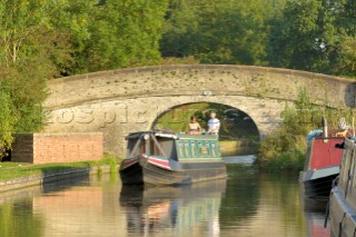 Couple on narrowboat passing under bridge 18 at Wheaton Aston on the Shropshire Union canal,Staffordshire,England,September 2006.