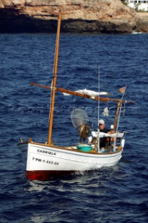 A fisherman out on his fishing boat in calm waters