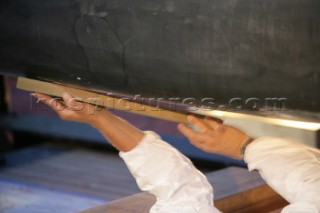 Crew sanding and preparing the bulb keel on BMW Oracle