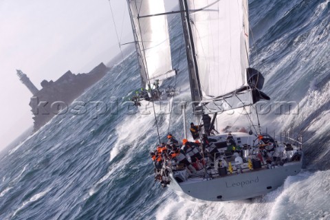 The super maxi Rambler racing around the Fastnet Rock Lighthouse chased by ICAP Leopard during the R