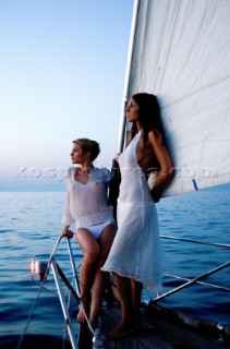 Glamorous female lifestyle model onboard a sailing yacht in the Mediterranean