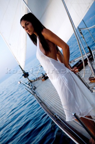 Glamorous female lifestyle model onboard a sailing yacht in the Mediterranean