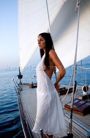 Glamorous female lifestyle model onboard a sailing yacht in the Mediterranean