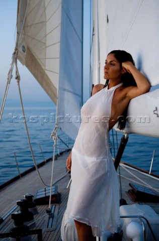 Glamorous female lifestyle model onboard a sailing yacht in the Mediterranean