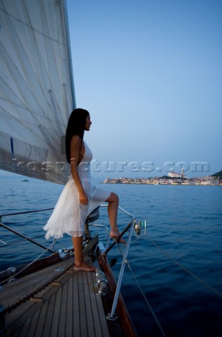 Glamorous female lifestyle model onboard a sailing yacht in the Mediterranean