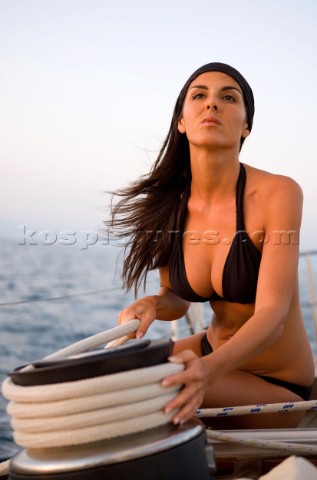 Glamorous female lifestyle model onboard a sailing yacht in the Mediterranean