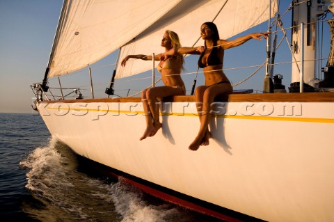 Glamorous female lifestyle model onboard a sailing yacht in the Mediterranean