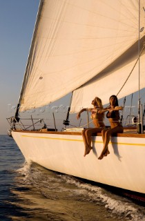 Glamorous female lifestyle model onboard a sailing yacht in the Mediterranean