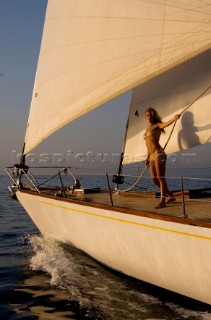 Glamorous female lifestyle model onboard a sailing yacht in the Mediterranean