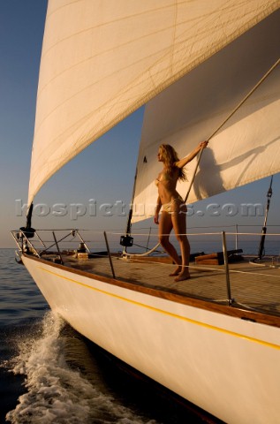 Glamorous female lifestyle model onboard a sailing yacht in the Mediterranean