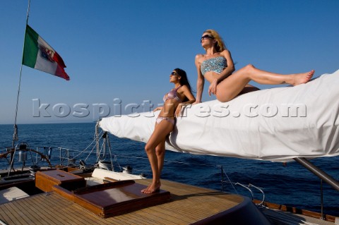 Glamorous female lifestyle model onboard a sailing yacht in the Mediterranean