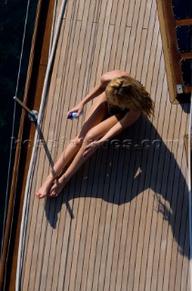 Glamorous female lifestyle model onboard a sailing yacht in the Mediterranean