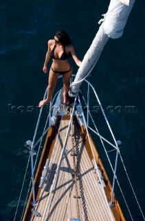 Glamorous female lifestyle model onboard a sailing yacht in the Mediterranean