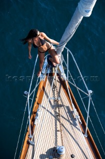 Glamorous female lifestyle model onboard a sailing yacht in the Mediterranean