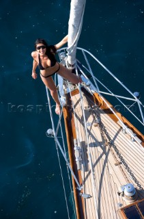 Glamorous female lifestyle model onboard a sailing yacht in the Mediterranean