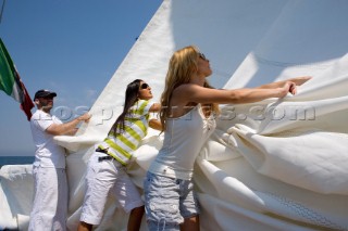 Glamorous female lifestyle model onboard a sailing yacht in the Mediterranean