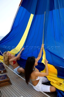 Glamorous female lifestyle model onboard a sailing yacht in the Mediterranean